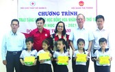 盧耀南理事長(右二)與本市、第五郡領導向五胞胎兄弟姐妹頒發獎學金。