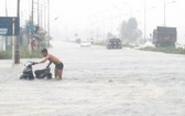 暴雨洪澇導致北-南1號國道途經河靖省路段交通癱瘓。（圖源：允和）