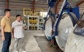 馬順通（左）與中國專家何明祥在研究新引進的無石棉矽酸鈣 板生產線。