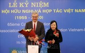 越-法合作與友協主任阮氏金進（右）向法國駐越南大使尼古拉斯‧華納贈送鮮花。（圖源：越通社）