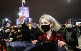 在波蘭首都華沙，數以千計的女性和年輕人當地時間週三晚不顧防疫限制，點燃火炬、揮舞支持性小眾權利的彩虹旗和與手持標語牌，上街抗議墮胎法令。（圖源：路透社）