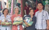 富山五行廟慈善組組長鄒國榮（右一）向貧困者派發賑濟品。