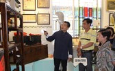 作者向懷舊物品捐贈者介紹陳列空間的西堤華人文物。