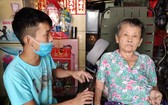 廖漢錦正照顧癱瘓的母親王桂英。