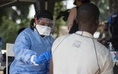 環形疫苗接種小組的一名成員正在博索洛村為一名男子接種疫苗。 （圖源：WHO）