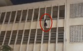 一名女生雙手攀住學校四樓護欄墜樓，懸掛在空中。（圖源：視頻截圖）