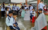 成員們在一所偏僻學校內為學生理髮。