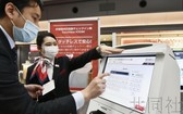 日本航空公司22日在東京羽田機場第一航站樓，推出了不直接用手碰觸觸控面板屏幕也可操作的值機設備和自動行李托運設備。（圖源：共同社）