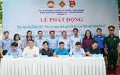 第五郡越南祖國陣線委員會副主席陳南德(右三前排)與第三、六、八、十、十四坊人委會簽署備忘錄。