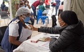 3月2日，工作人員在南非約翰內斯堡的一家醫院為前來接種新冠疫苗的醫護人員測量體溫。（圖源：新華社）