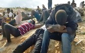 錄像片段顯示了該沉船事故中的數十名倖存者，他們坐在al-Khums海岸的沙灘上。（圖源：AFP）