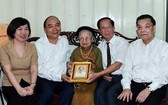 國家主席阮春福（左二）與河內市領導一同探望阮泰來烈士母親阮士秀並贈送禮物。（圖源：統一）