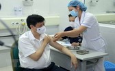醫護人員為衛生部長阮清隆（左）注射新冠疫苗。（圖源：越通社）