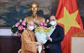 國家主席阮春福（右）接見越南佛教教會理事會理事長釋善仁和尚時贈送鮮花祝賀。（圖源：越通社）