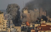 加沙城一處建築在以色列空襲中倒塌，現場升騰起濃煙。（圖源：互聯網）