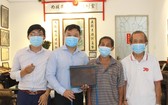 一等抗戰勳章獲得者周純光先生（左三）向陳列室捐贈母親遺物。
