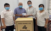 華人企業家呂永雄(左二)向第五郡第四坊領導轉交支持防疫物資。