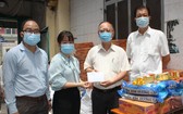 穗城會館理事長盧耀南(右二)和副理事長林海泉(右一)向坊領導移交支持防疫物資和現金。