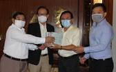 萬盛發集團代表張豐裕（左二）向二府會館理事會和建築公司代表移交最後一期捐款。