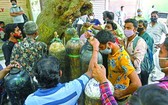 新德里居民攜氧氣鋼瓶排隊等待為居家隔離的新冠患者充醫用氧氣。（圖源：互聯網）