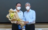 阮玉強同志（左）從市人委會副主席武文歡手中接過委任《決定》和祝賀鮮花。（圖源：廷李）