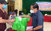 守德市越南祖國陣線委員會主席陳友福向外籍人贈送禮物。