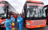 民眾穿著防護服準備搭乘免費班車離開本市返回福安省。