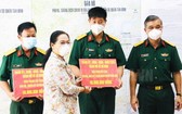 市人民議會主席阮氏麗（左二）向正在本市參加新冠肺炎疫情防控工作的軍隊幹部、戰士贈送禮物。（圖源：市黨部新聞網）