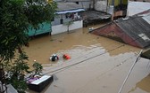 2021年2月8日，印尼雅加達，大雨造成洪水氾濫，一名居民正在撤離。 (圖源：AFP)