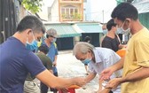 平治東坊自由舊村的村民領取救濟品。