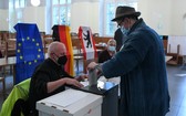 柏林投票站一名選民（右）參加聯邦議院選舉投票。（圖源：新華社）