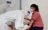 一名女性接受血液取樣以檢測新冠病毒抗體數量。（圖源：何明）