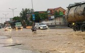 途經乂安省黃梅市的1號國道路段受淹嚴重，車輛行駛十分不便。（圖源：TTO）