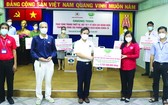 慈濟慈善會越南人醫會黃清俊醫生（中）向鄧氏明孝副主席轉贈醫療裝設備及醫用品。