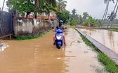 10月16日，在印度南部喀拉拉邦首府提魯沃嫩塔布勒姆，一名男子在積水中騎行。（圖源：新華社） 