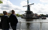 圖為遊客在荷蘭哈勒姆欣賞一座建於1779年的風車。（圖源：新華社）