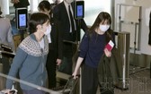 11月14日上午，秋筱宮長女真子手持護照啟程前往美國，左為她的丈夫小室圭。（圖源：共同社）