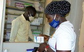 在新冠大流行期間，一名感染艾滋病毒的婦女在烏幹達的一個健康中心取藥。（圖源：聯合國）