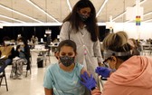 一名12歲的女孩在媽媽陪伴下在美國伊利諾伊州德斯普蘭斯接種輝瑞疫苗。（圖：AP）