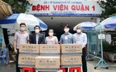 市越南祖國陣線委員會和越英長大興國際藥品股份公司代表向第一郡醫院移交援助新冠確診者的藥物。