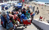 湯加火山爆發後，智利地方當局發出海嘯預警，在海岸邊遊玩的人們紛紛撤離。（圖：路透社）