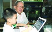 小學一年級的華人子弟居家線上學習總是有長輩陪伴。