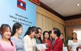 越南助學協會主席阮氏緣向老撾留學生頒發助學金。（圖：青松）