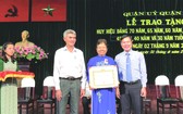 第五郡領導向華人黨員李金梅 頒贈50年黨齡紀念章。