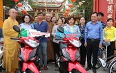 本市領導與釋慧功上座向2戶華人家庭贈送摩托車。