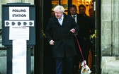 英國首相鮑里斯‧約翰遜在一個投票站投票後牽著他的小狗離開。
