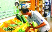 顧客在“家鄉市集”綠色產品商店購買蔬菜。