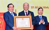 市委書記阮文年向東方發展研究院頒授二等勞動勳章。