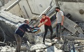 以色列發動襲擊後，人們從加沙的一座受損建築中搶救財產。