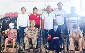 理事長鄭成龍(後排左三)等向殘疾人士 贈送輪椅。